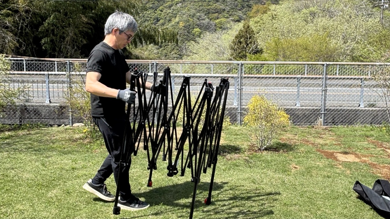 ワンタッチタープを広げる男性